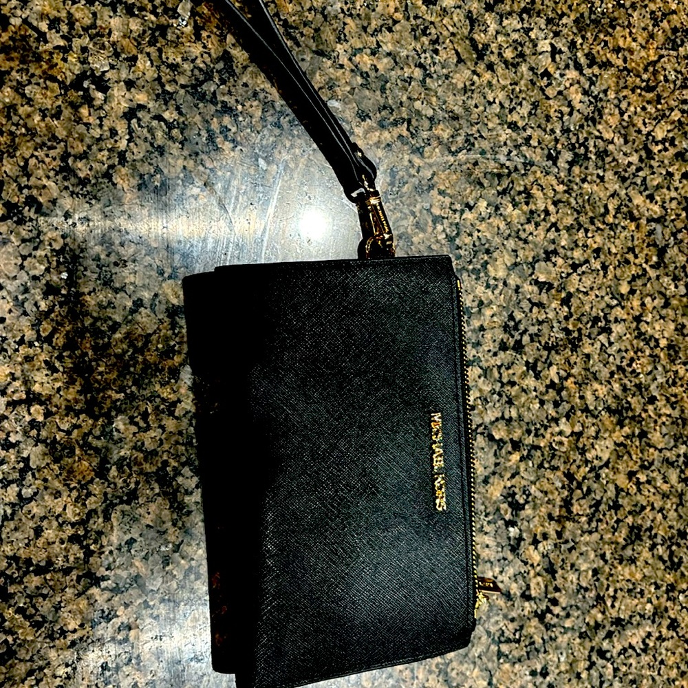 Michael Kors wristlet used on one trip.  Black with gold zipper.  Like new